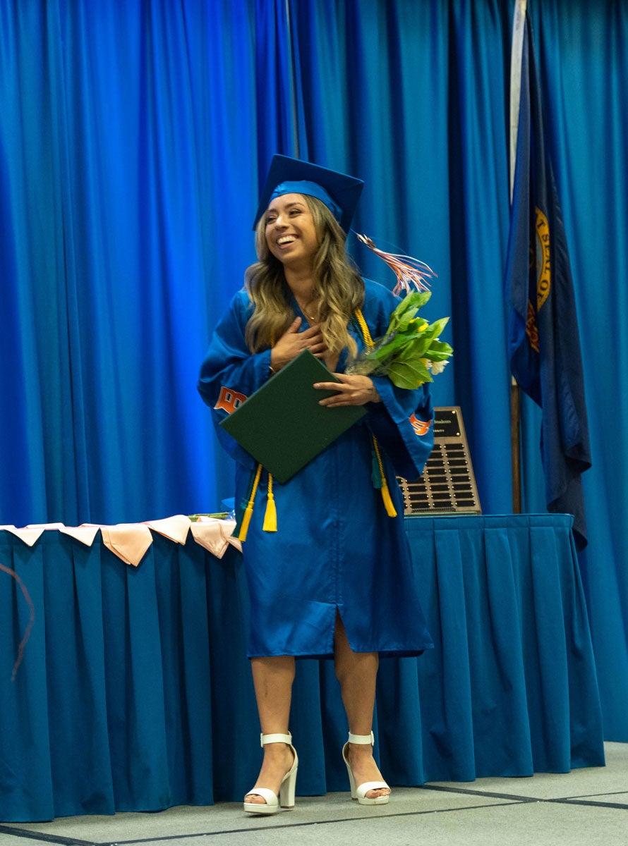 Yessie Espinoza with student Daisy Award and a bouquet of flowers.