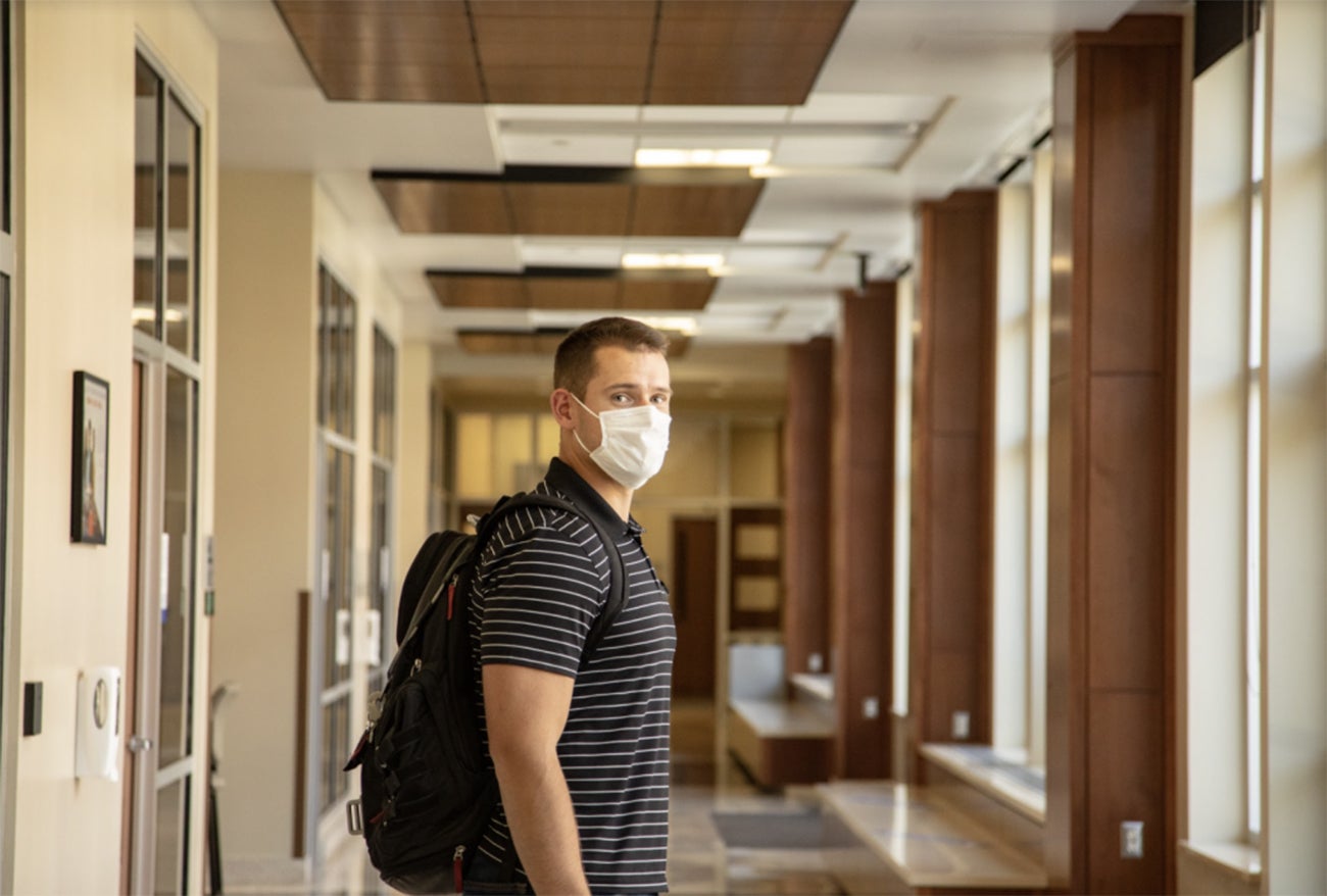 Master of Science in Accountancy student Mason Hampton inside of a building and wearing a facial covering.