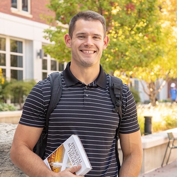 Mason Hampton stands in front of the COBE building on campus.