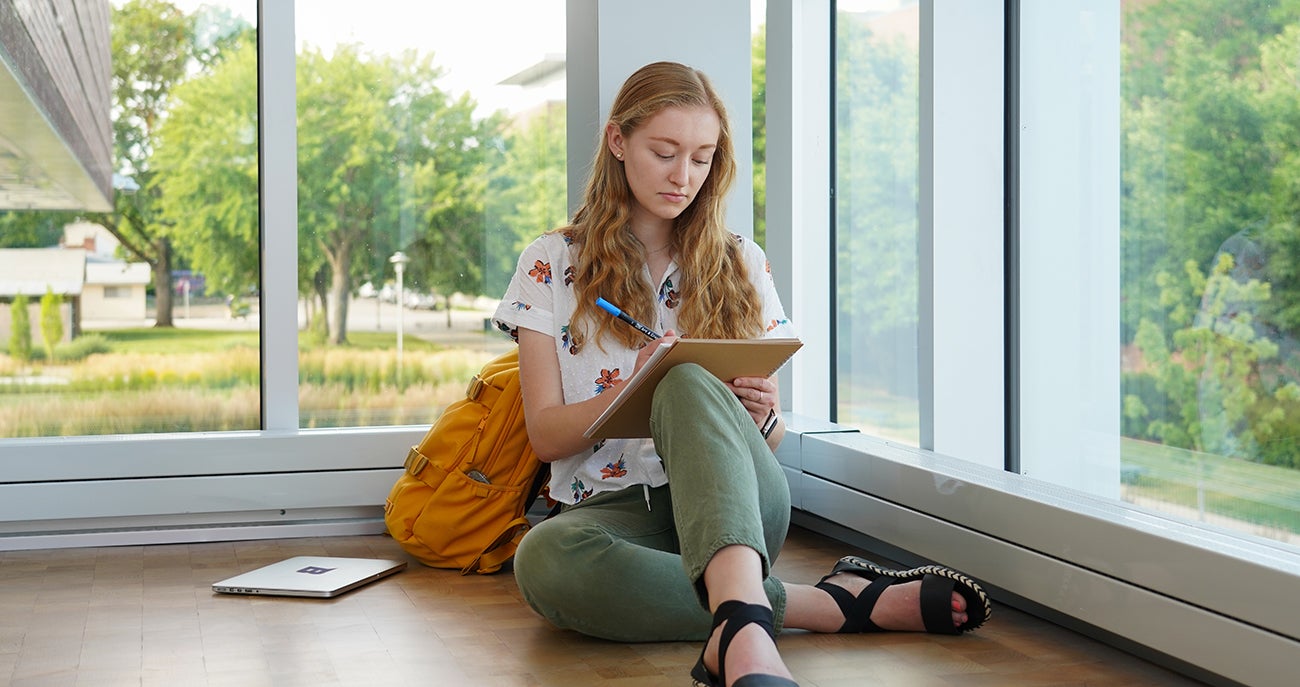 Digital Innovation and Design Student sits by a window