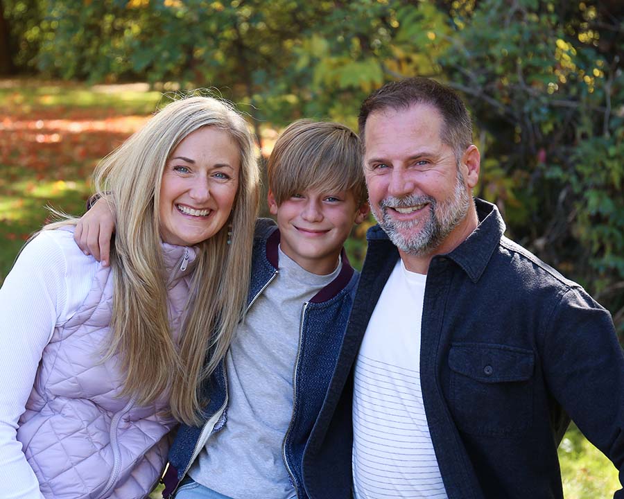 Meg Omel next to two family members, smiling for camera.