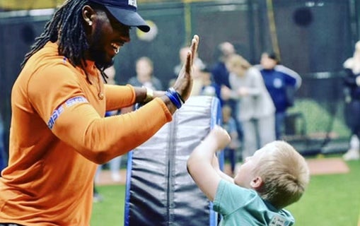 Alexander Mattison practicing football with a young boy.