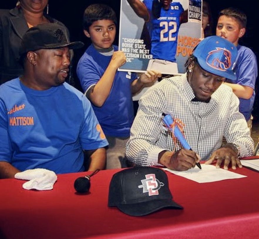 Alexander Mattison sits at a table with a pen.