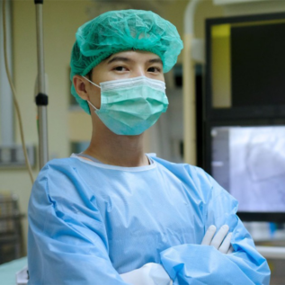 An imaging technologist stands in front of their equipment.