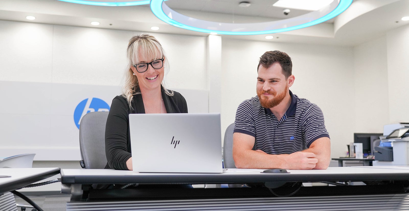 Cybersecurity student, Kristi Pruett, working on a computer with a coworker