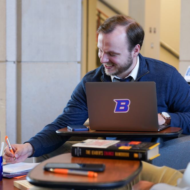Student sitting behind laptop