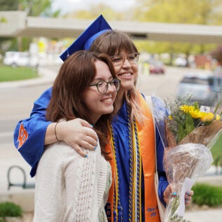 A boise state graduate posing for a photo with a loved one