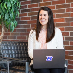 Wendy Berkson sits in front of a laptop and smiles.