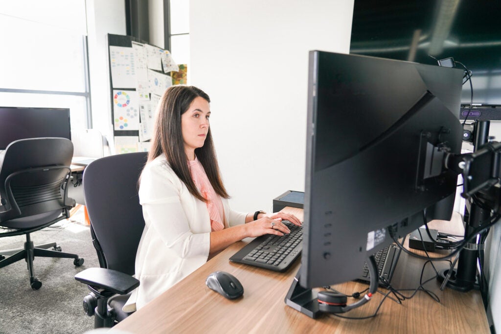 A business professional types on a computer