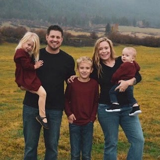 Ashley Mack, her husband, and three kids posing for a family photo
