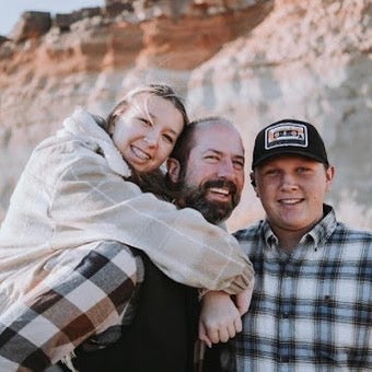 Shea McNama giving a piggyback to his daughter as his son stands close near by