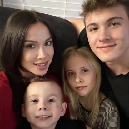 Stevie Lewis, her husband, daughter and son smiling for a family photo