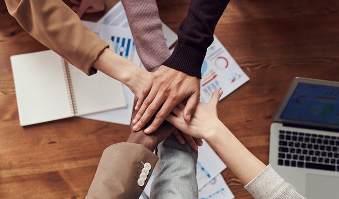 A group of people putting their hands together