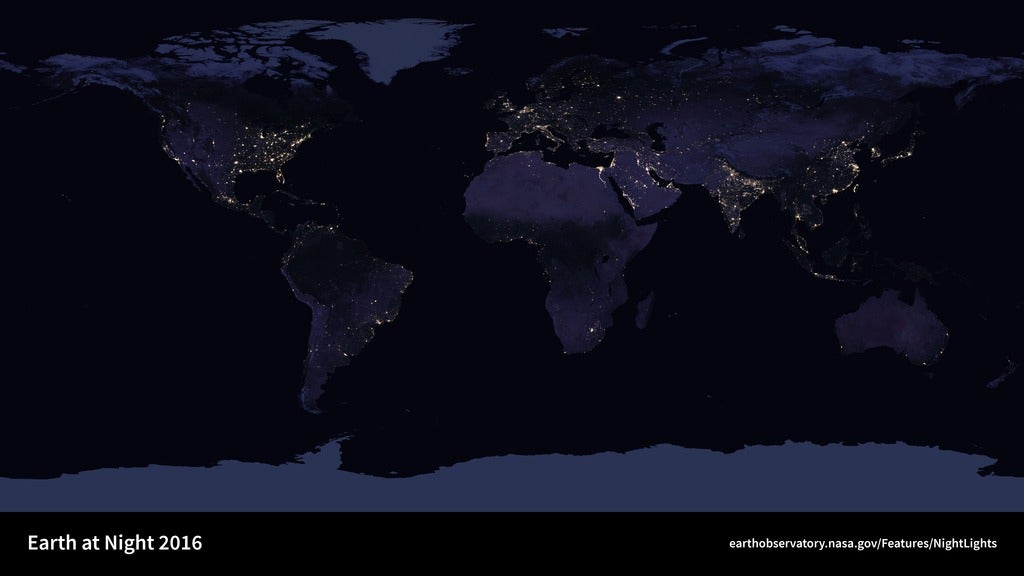 Earth at night with lights dotting cities around the world.
