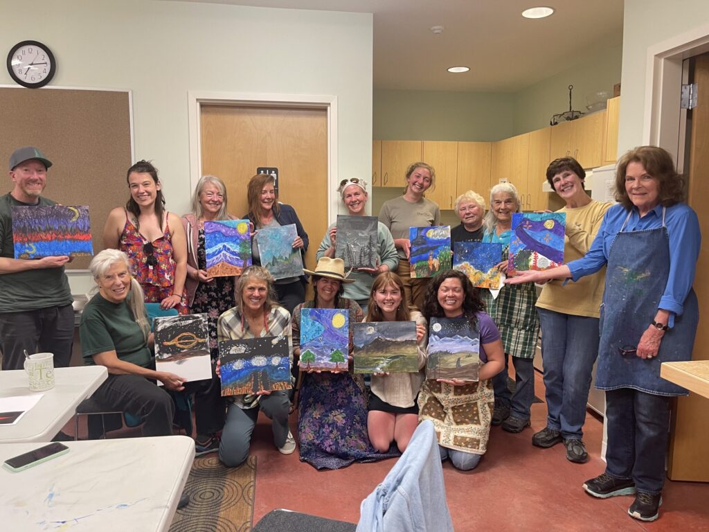 A group photo holding their paintings.