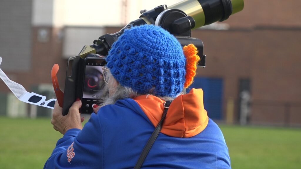 A woman peers through a telescope at a viewing party of the solar eclipse. 