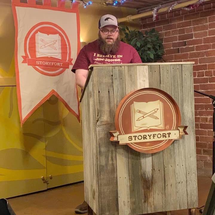 John Barrie reading behind a podium
