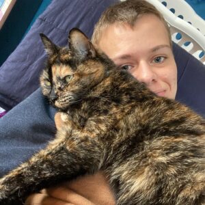 Lauren with a small black and orange cat lying on her lap