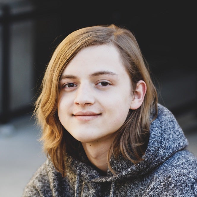 A portrait of Jaime Geary, looking into the camera with a slightly disgruntled smile.