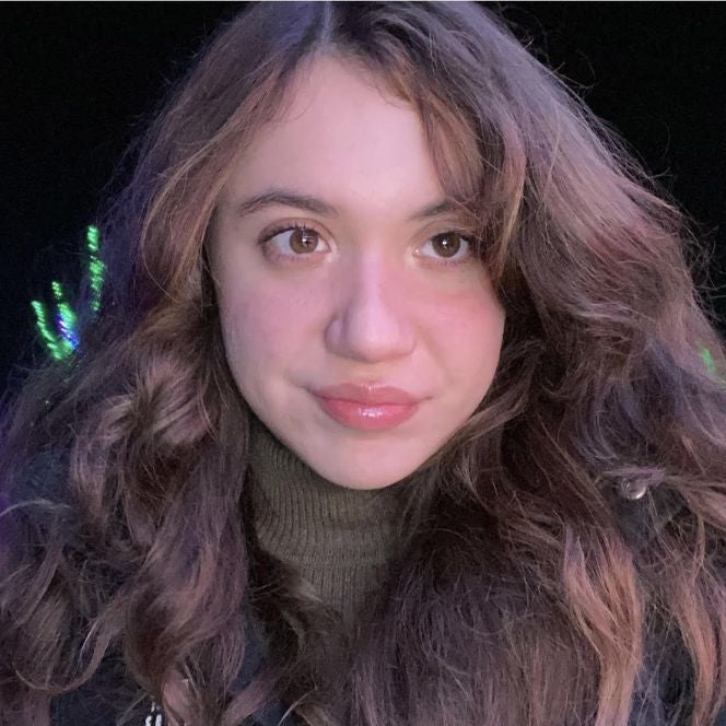 Samantha Caccamo is photographed against a darkened background, her face at the forefront of the portrait.
