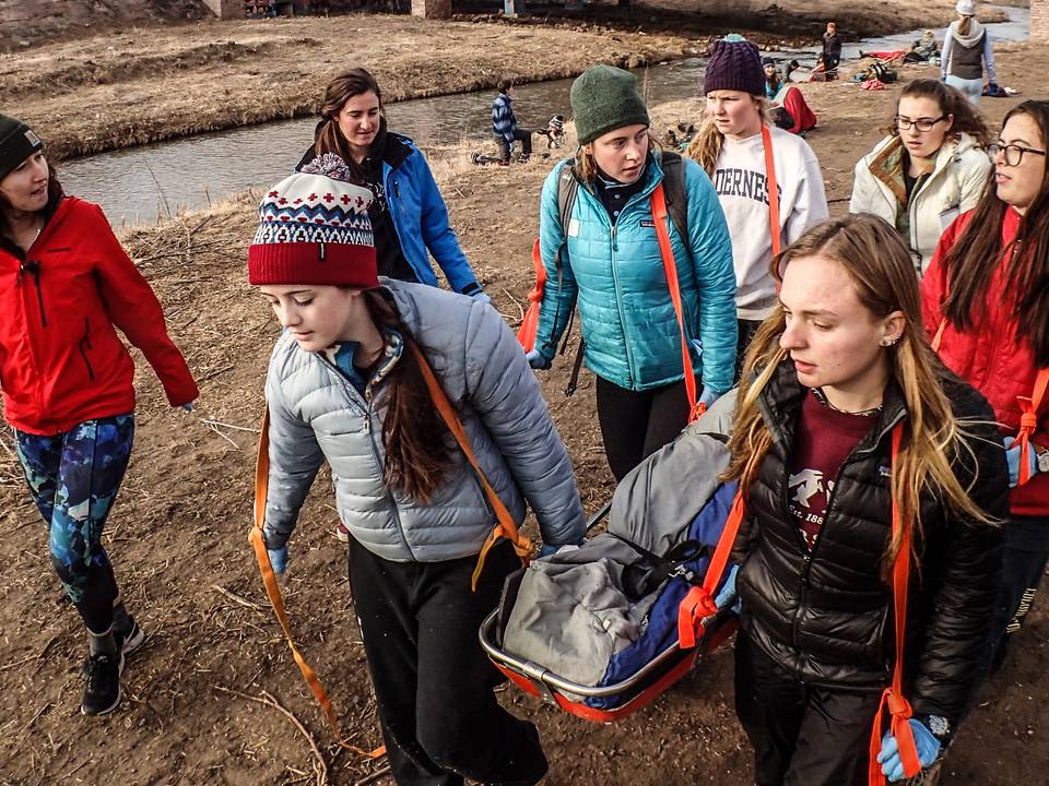 students working together to carry a stretcher during training
