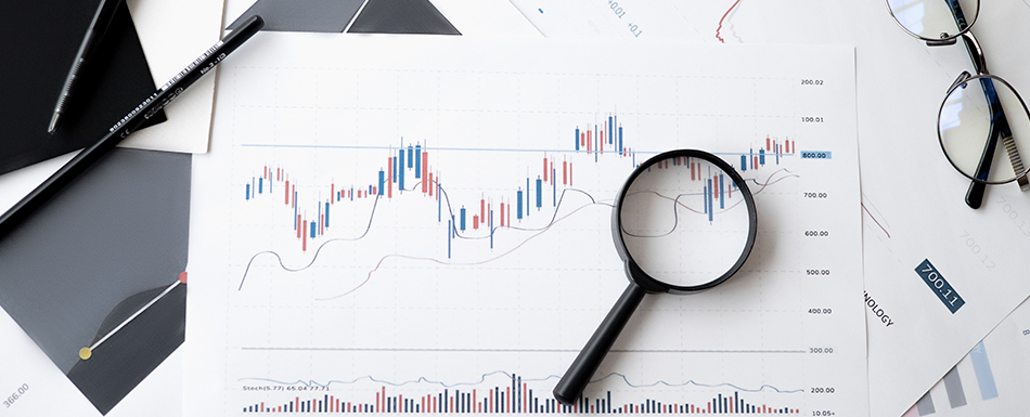 magnifying glass and glasses on top of a data graph