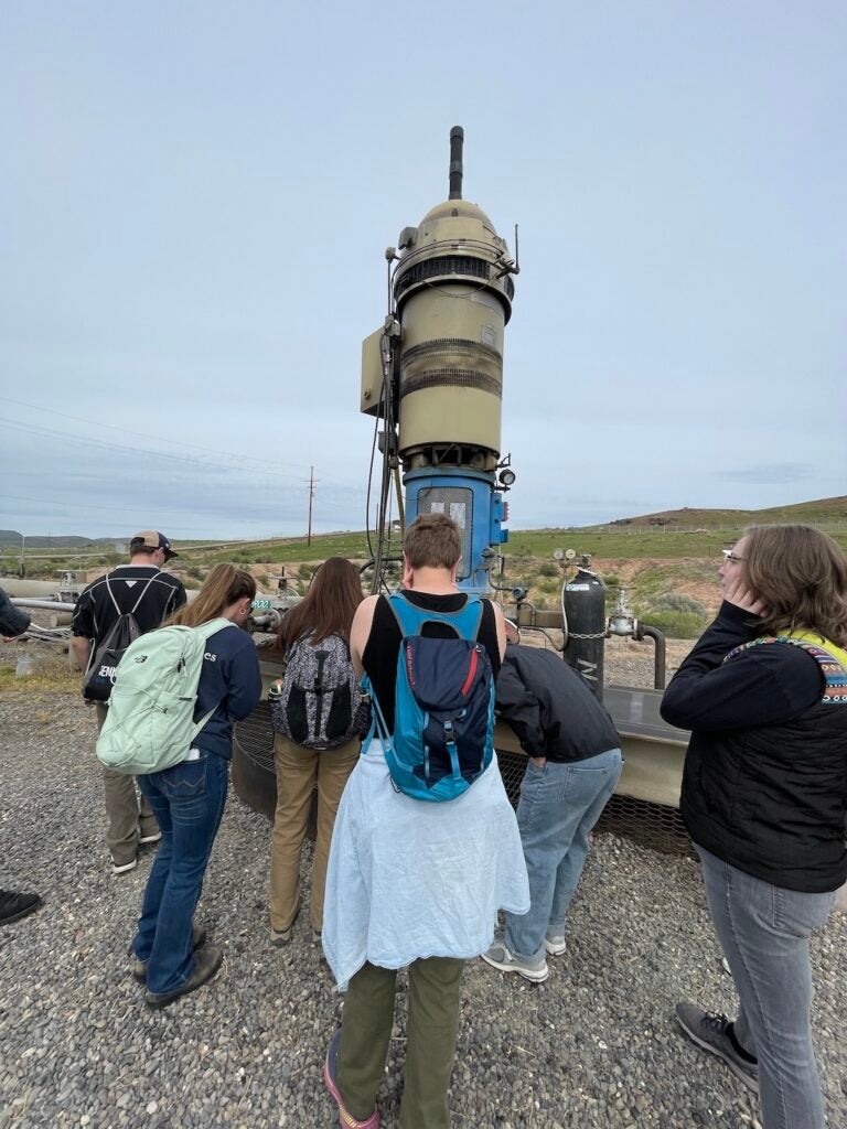 Students gathered around the Neal Hot Springs Geothermal Power Plant.