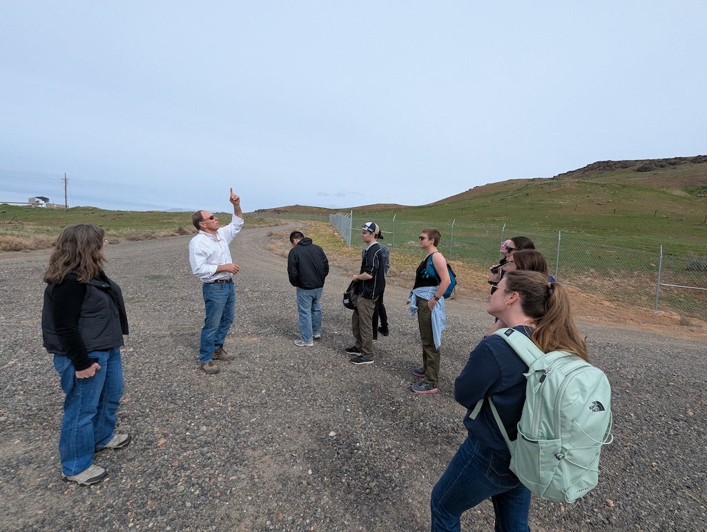 Nichols points to the sky while explaining to the students.