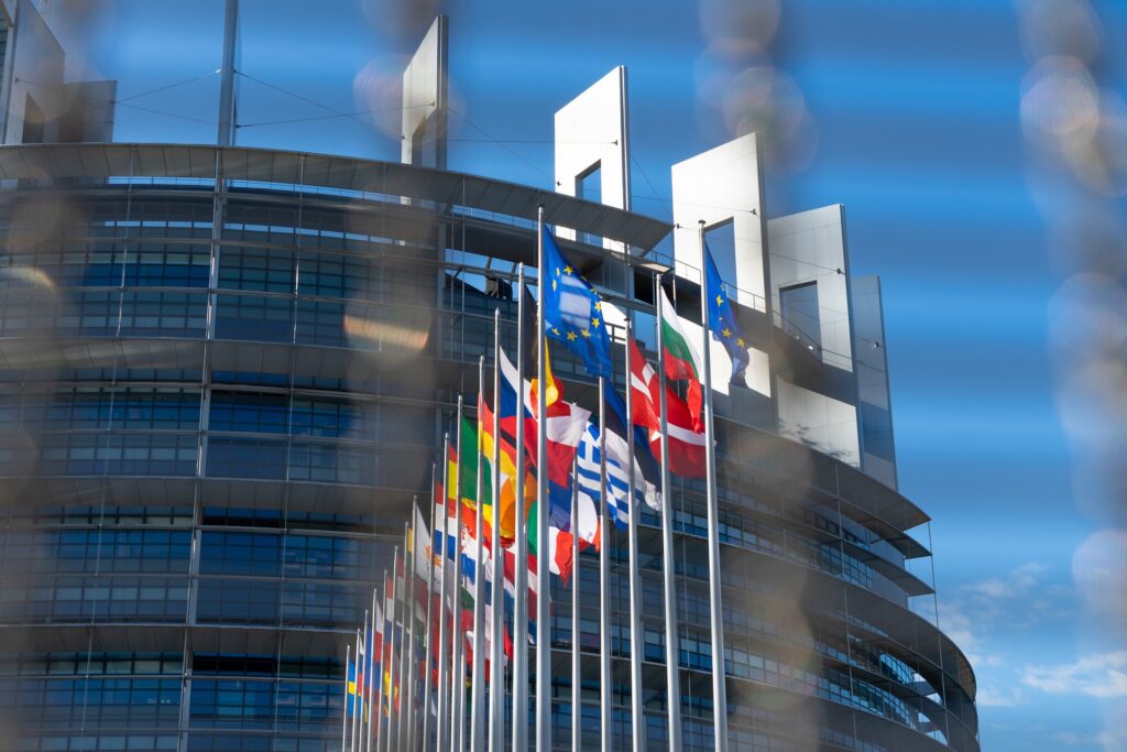 building with multiple county flags in the center blowing in the wind