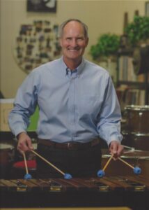 Man smiles while paying xylophone