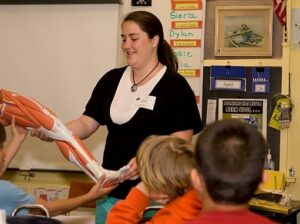 zoology student giving a demonstration to elementary students