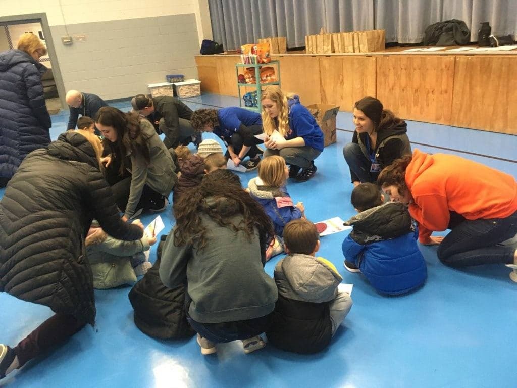 Nursing students working with students on their how are you feeling forms.