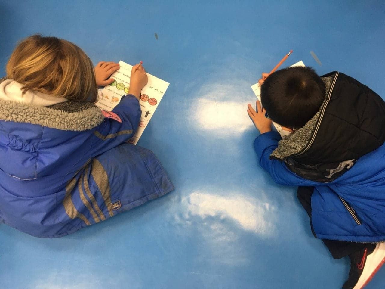 two students filling out the how are you feeling form.