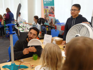One person showing a child how a windmill works