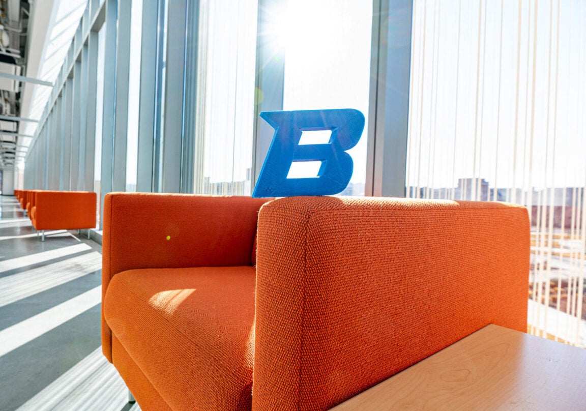 Naturally illuminated interior hallway with chairs and Boise State logo