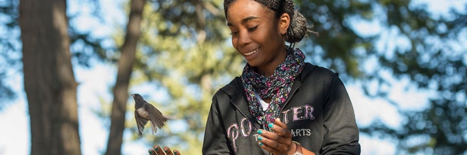 student releasing a bird