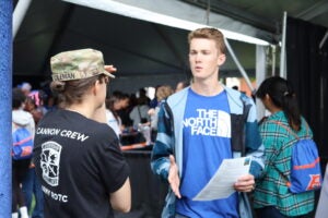 Cadet talking to person at football game