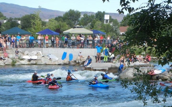 Kayakers surf at the wave park. 