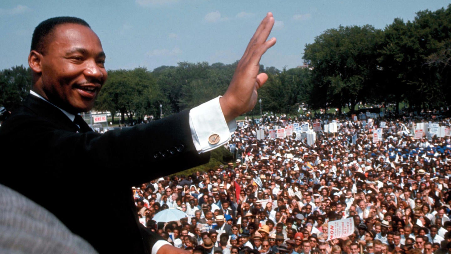 King waving to a large crowd