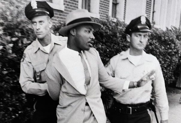 King pictured being arrested by two police officers.