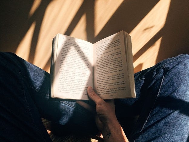 person sitting with an open book in their lap