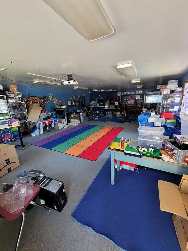 An elementary classroom with a colorful rug. 