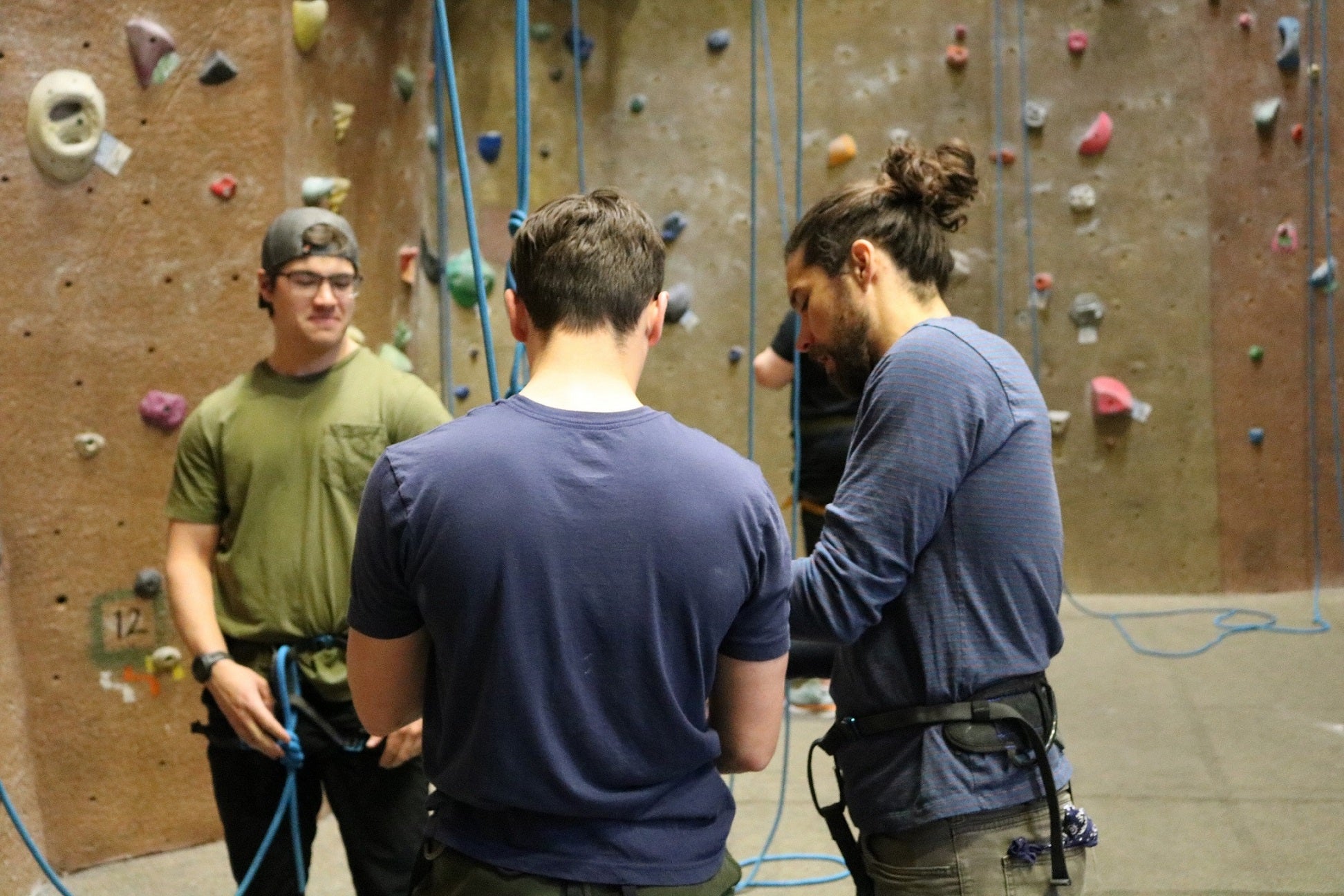 Zack heads to the wall and ties the rope into his harness.