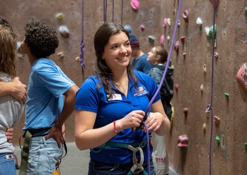 Student rock climbing instructor