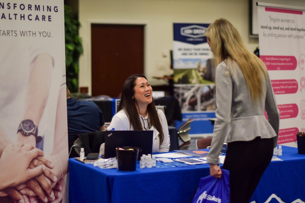 Student speaking to representative at career fair