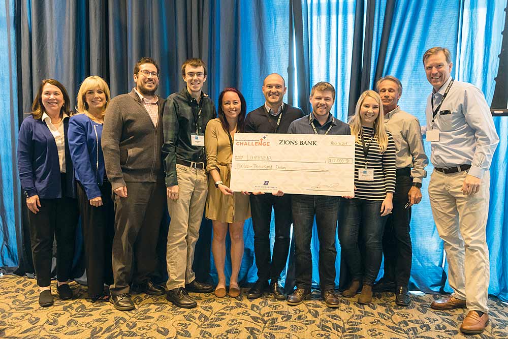 Lumineye group members holding a check for $12,000