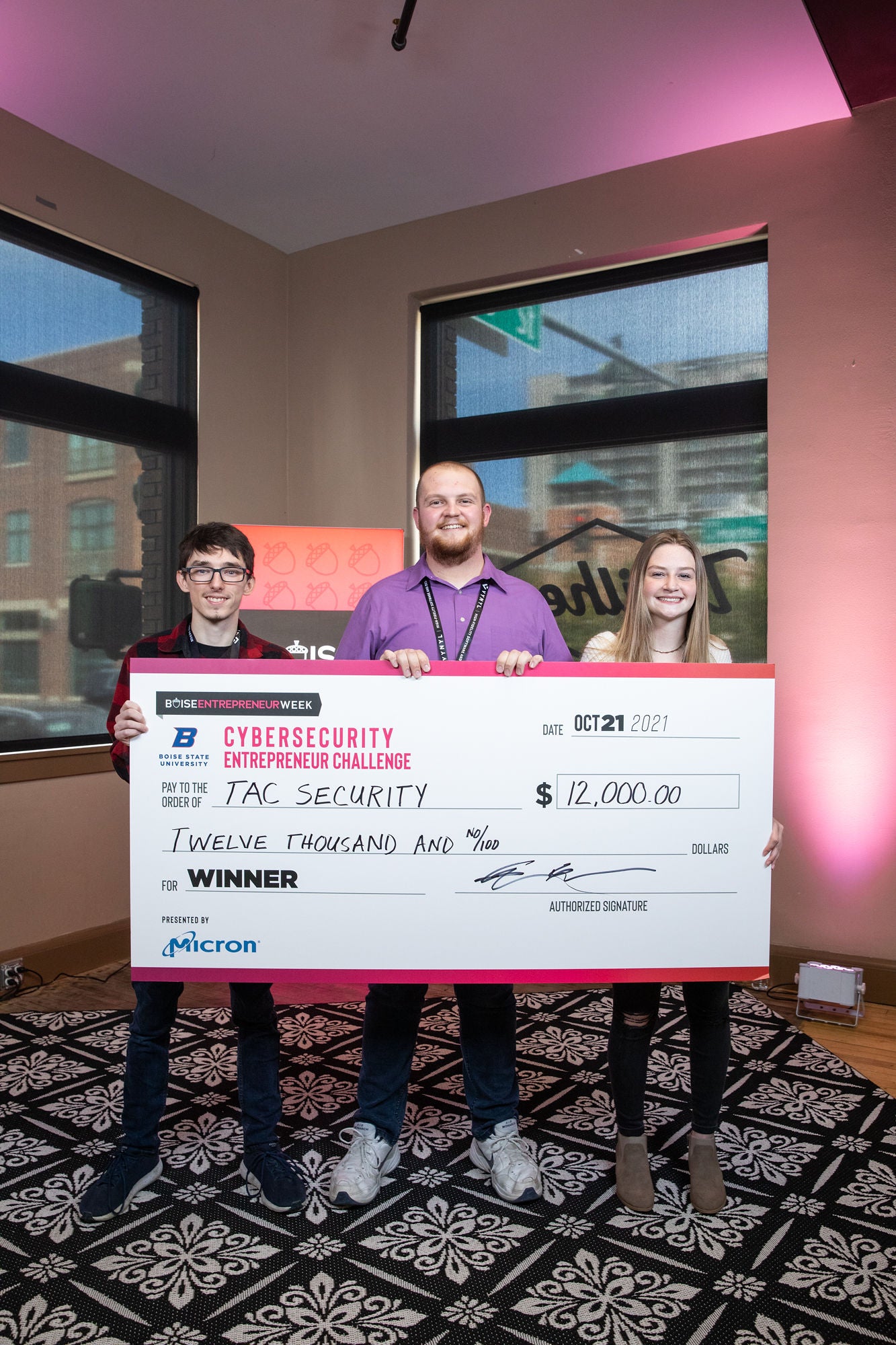 TAC Security members hold a large check $12,000.