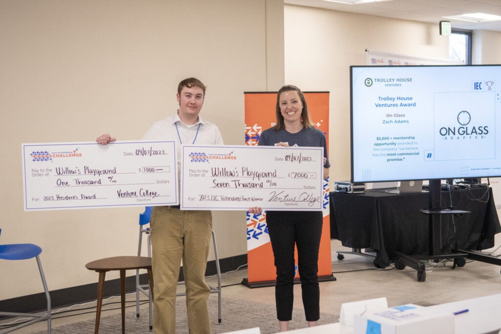 Jacob Brown, Willow’s Playground holds check's for $1,000 and $7,000 