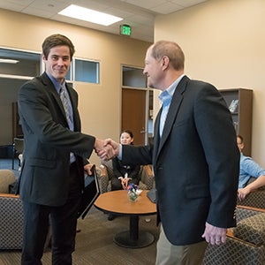 Boise State accounting student, John Jenkins shakes hands with Marc McDonald of Deloitte