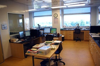 control room with access and viewing window into mass spectrometry room